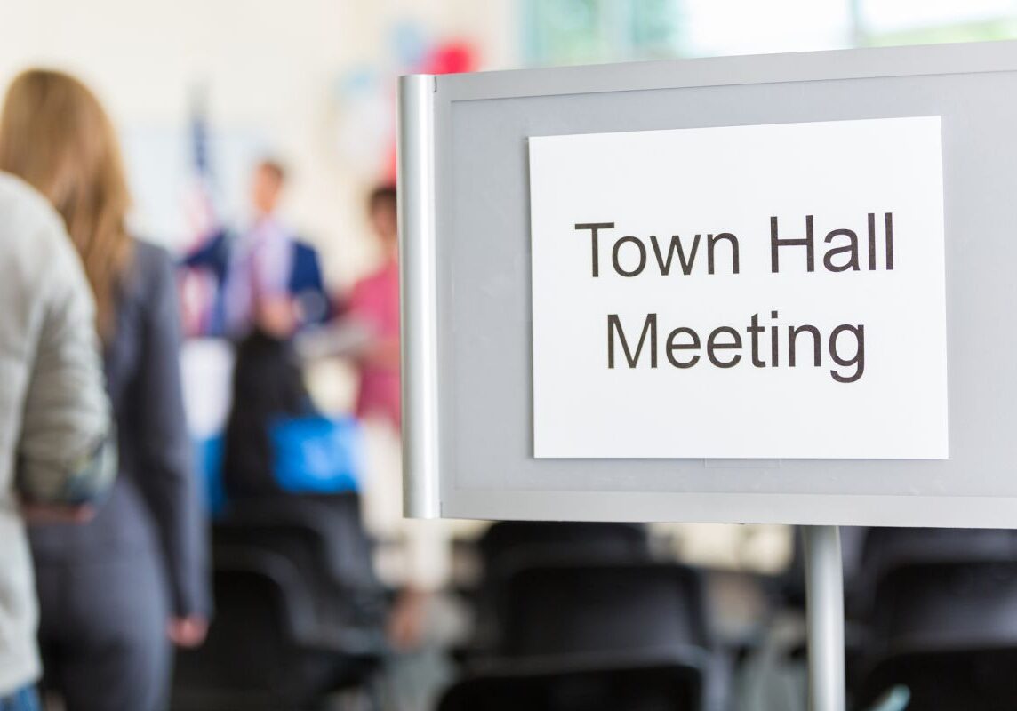 A sign that says town hall meeting